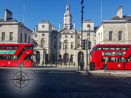 Red london busses passing in front of Church